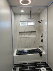 Tiled shower with a built-in niche above a dark tile floor