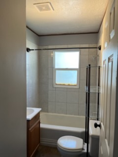 Bathroom with a tub, tiled surround and an oak vanity