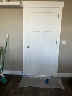 Interior door and painted wall with a drop cloth down