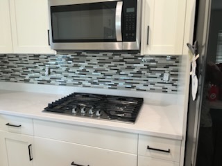 Mosaic tile backsplash behind a cooktop