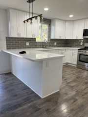 Grey subway tile and a peninsula counter in a finished kitchen