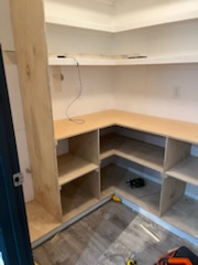 Shelving carcass under construction against a timber post