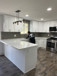 Finished kitchen with a tiled wall and a peninsula counter