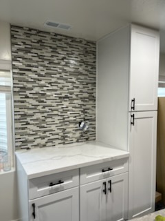 Mosaic tile feature wall above a counter and drawers