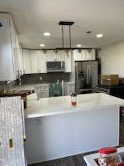 Tiled backsplash in a finished kitchen with stainless appliances