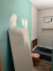 Bathroom with board and a framed niche up and the new tub in place