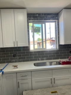 Grey subway tile behind a kitchen window