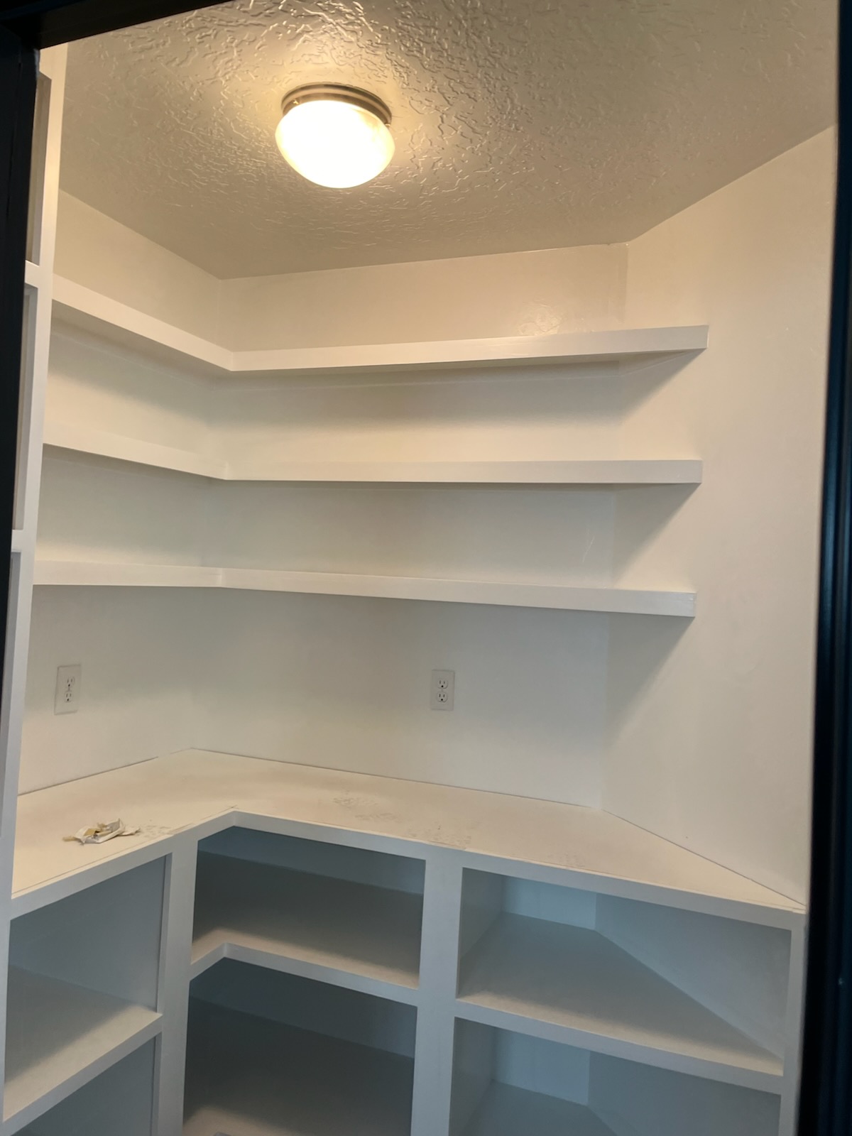 Fitted white pantry shelving built into a corner