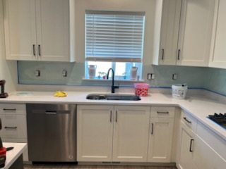 Glass tile backsplash set behind a kitchen sink